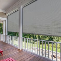 a porch with two red benches on it and a large window covered in cellular shades