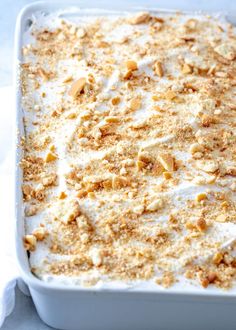 a casserole dish filled with white cream and chopped walnuts, topped with crumbs