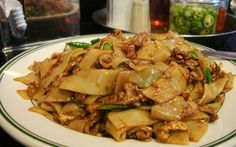 a white plate topped with noodles and meat