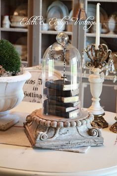 a white table topped with a glass dome filled with books