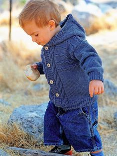 a little boy standing on top of a rock