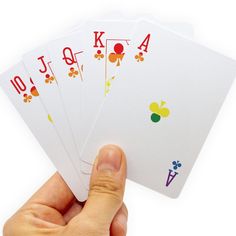 a hand holding four playing cards with the letter k on each card in different colors