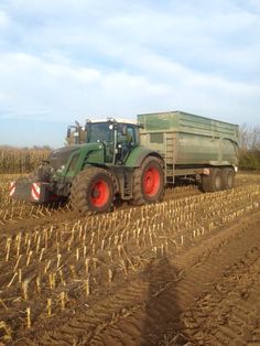 a tractor is driving in the middle of a farm field with corn stalks on it