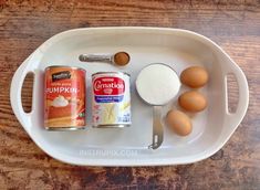 ingredients to make pumpkin muffins in a white tray on a wooden table top