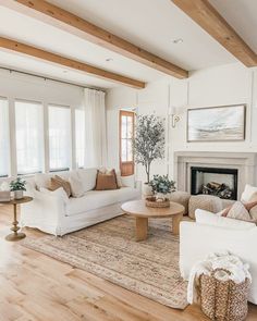 a living room filled with furniture and a fire place in the middle of a wooden floor