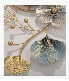 three gold and blue seashells hanging on a wall