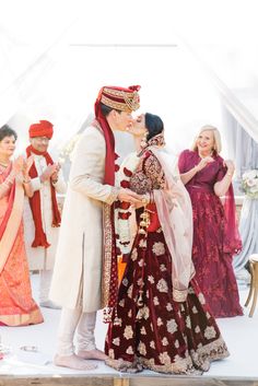 a bride and groom kissing in front of their guests at the end of their wedding ceremony