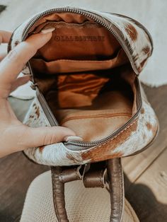 a person is holding the inside of a brown and white purse