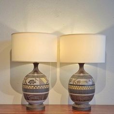 two lamps sitting on top of a wooden table