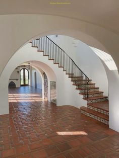 an arched entryway with stairs and tile flooring