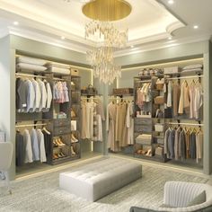 a walk in closet with chandelier and clothes on hangers next to a couch