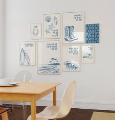 a dining room table with chairs and pictures on the wall above it in blue and white