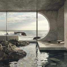 an indoor swimming pool in front of a large window overlooking the water and rocks on the beach