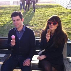 three people sitting on a bench eating ice cream