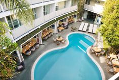 an aerial view of a hotel pool with tables and chairs