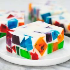 a white plate topped with multicolored jello bars on top of a table