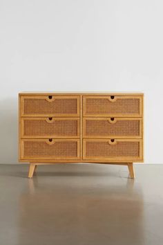 a wooden dresser with wicker drawers on it