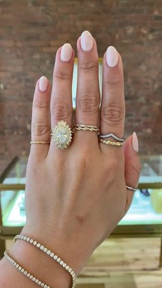 a woman's hand with three different rings on her left and the middle finger