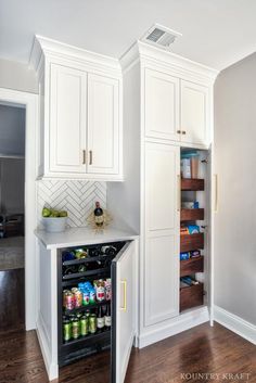 a kitchen with white cabinets and wood floors