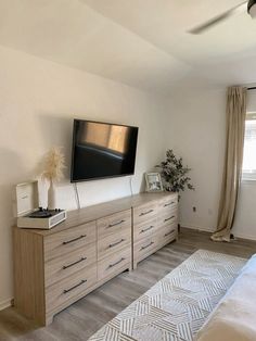 a flat screen tv sitting on top of a wooden dresser