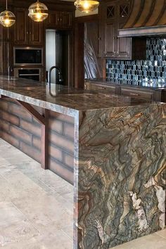 a large kitchen with marble counter tops and wooden cabinetry, along with an island