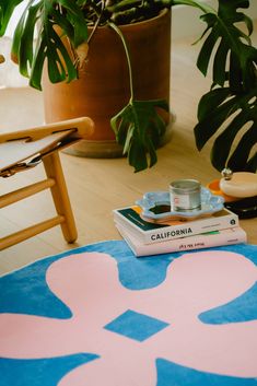 a stack of books sitting on top of a blue and pink rug