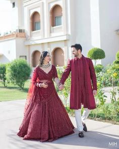 a man and woman dressed in red holding hands