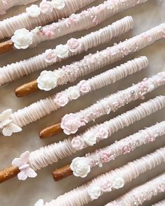 there are many pink and white flowers on the sticks that have been made out of candy canes