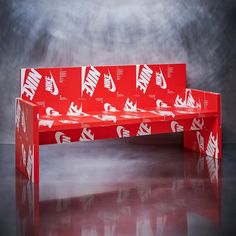 a bench made out of red boxes with white nike logos on the back and sides