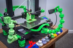 a green and black 3d printer sitting on top of a table