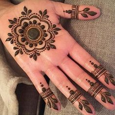 a woman's hand with henna tattoos on it