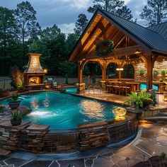 an outdoor pool surrounded by stone patio and gazebo with lights on the roof above it