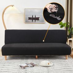 a black couch sitting on top of a white rug