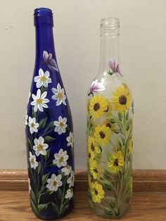 two glass bottles with painted flowers on them