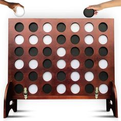 a wooden game board with holes in the middle and two handles on each side, set against a white background