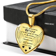 a gold heart shaped necklace with an inscription on the front and back, sitting next to a box