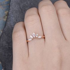 a woman's hand with a diamond ring on top of her finger and the other hand holding it