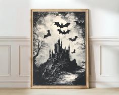 a black and white poster with bats flying over a castle in the sky, on a wall