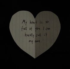 a paper heart with writing on it in the dark