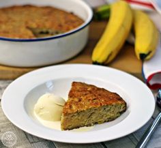 a piece of cake on a plate with ice cream and two bananas in the background