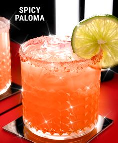 two glasses filled with drinks sitting on top of a red table