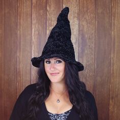 a woman wearing a black knitted witches hat