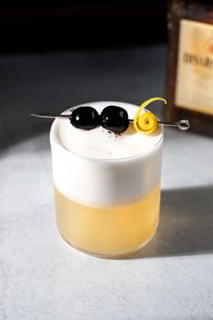 two black olives are on top of a drink