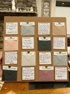 a cork board covered in lots of different colored envelopes