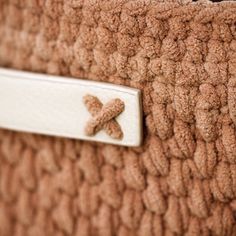 a close up view of the inside of a brown purse with a white tag on it