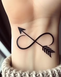 a wrist tattoo with an arrow on it