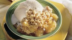 a plate topped with ice cream and fruit cobbler next to a slice of bread