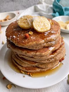 a stack of pancakes topped with bananas and syrup