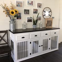 a dog house with pictures on the wall and flowers in vases next to it