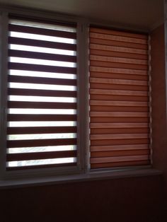 two windows with wooden blinds in a room